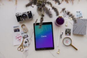 Aesthetic flat lay featuring a tablet, camera, and creative accessories on a white background.